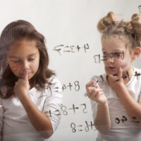 Two girls are making their mathematic assignment