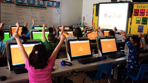 Kids cheering for kahoot with computers