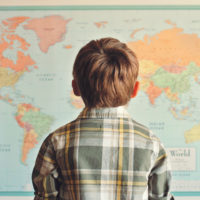 Little boy looking at world map