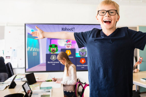 Boy in a classroom celebrating after playing Kahoot!