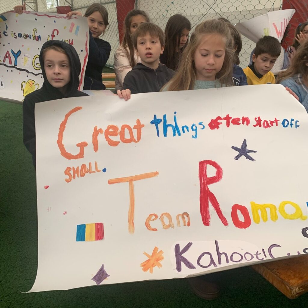 Students posing with poster that reads, "Great things often start off small. Team Romania, Kahoot! Cup 2024"