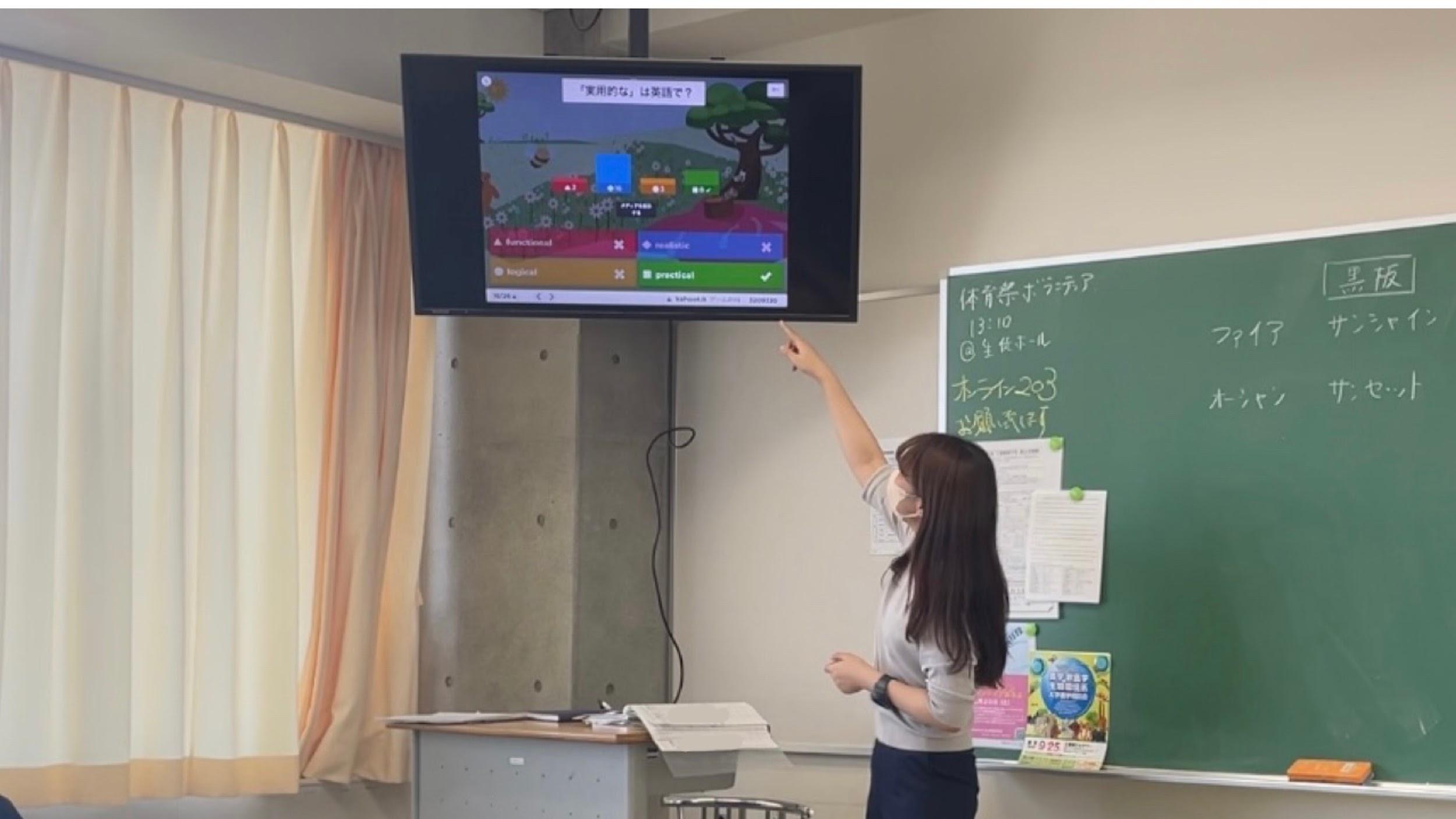 Teacher pointing to mounted TV with kahoot screen on display