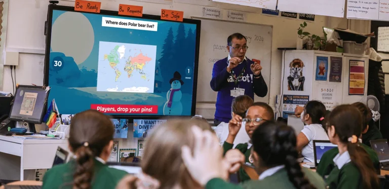 Group of children and their teacher playing kahoot in the classroom