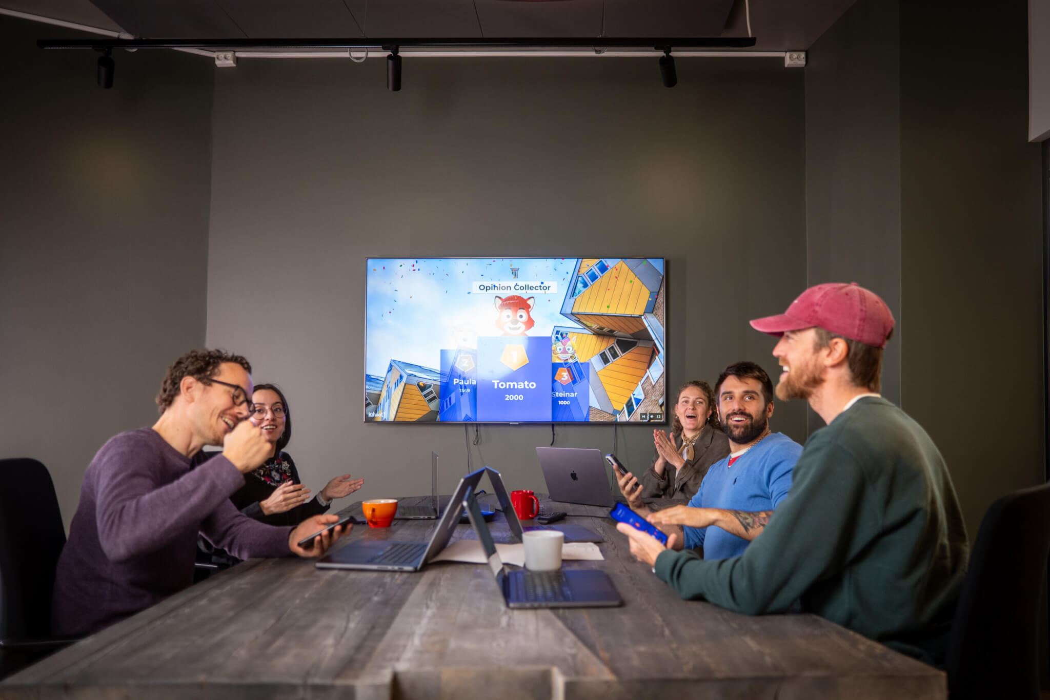 Professionals playing a kahoot at a conference table 
