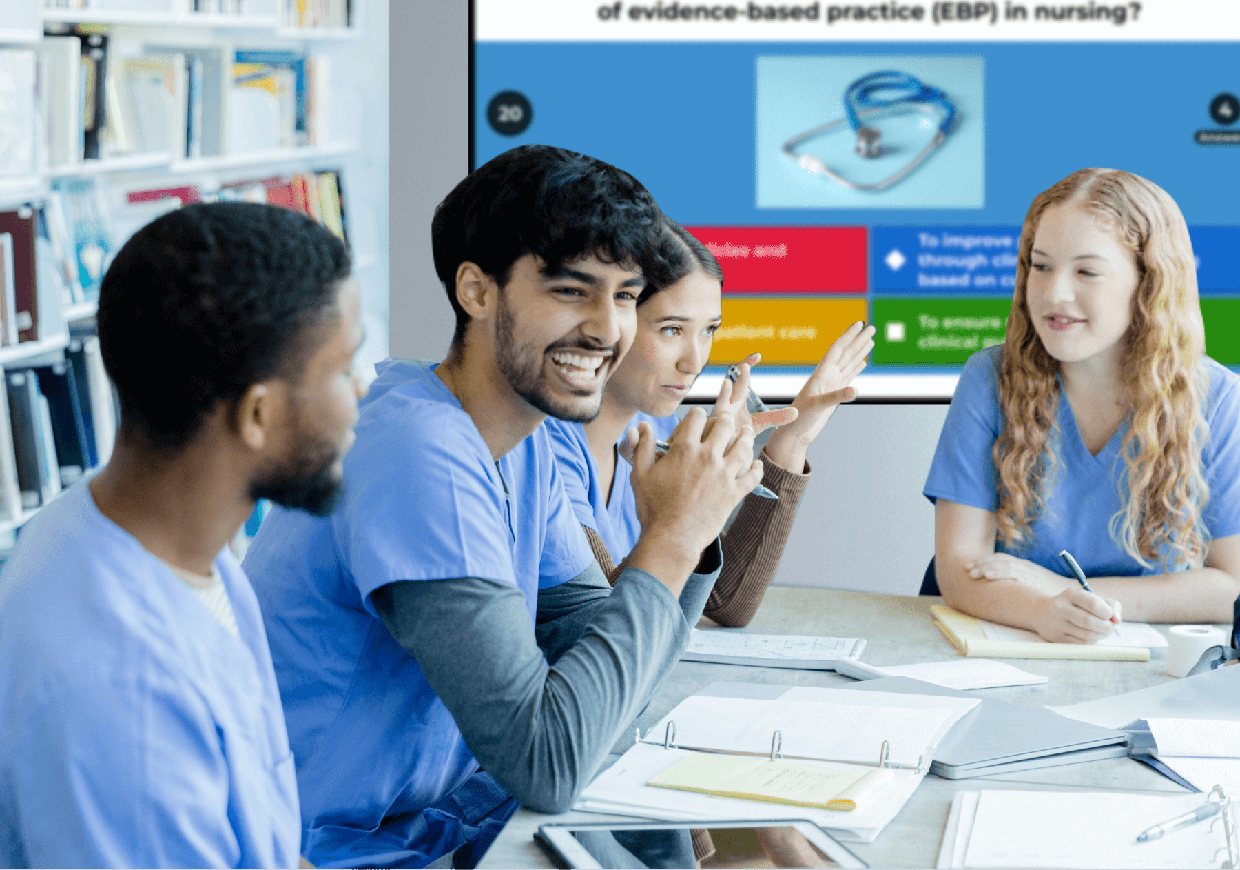 Young adults in medical scrubs sitting at a table and playing a kahoot
