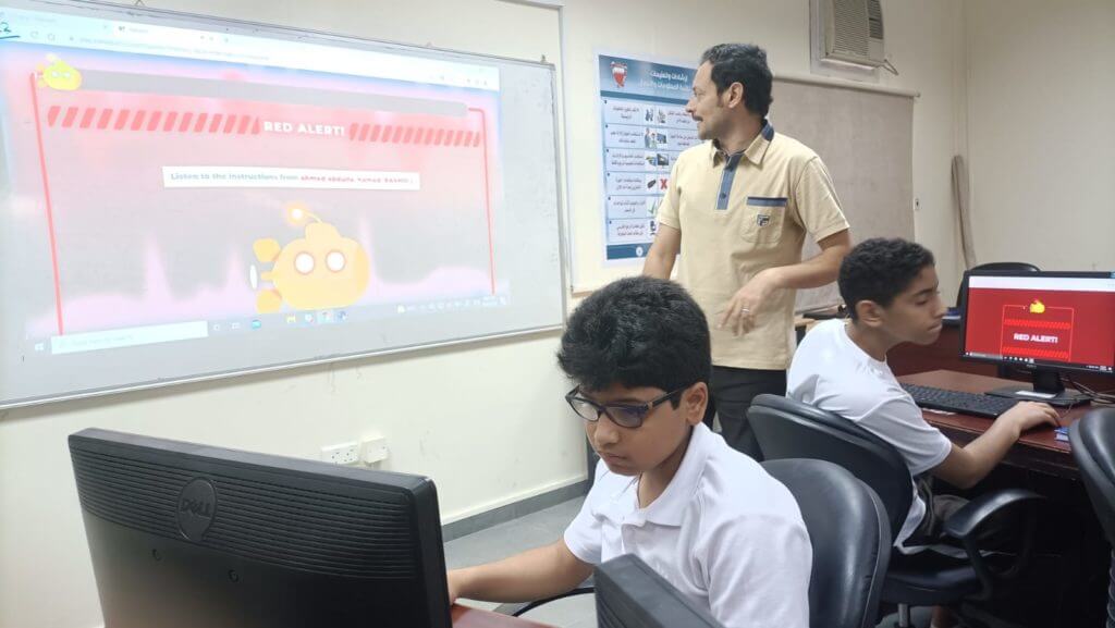 A teacher hosting a kahoot on a classroom projector and students playing on computers. 