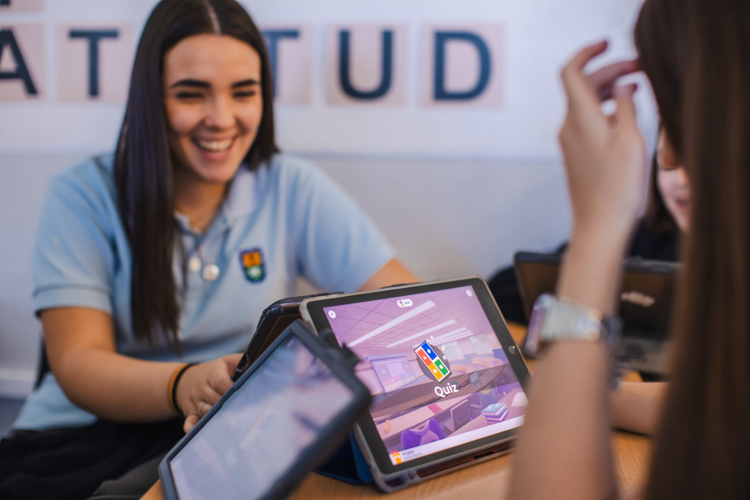 Students playing Kahoot! at a table in a classroom