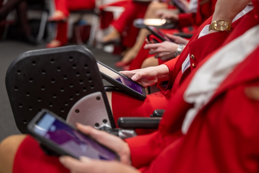 Group of Virgin Atlantic flight attendants using tablets during in-class learning