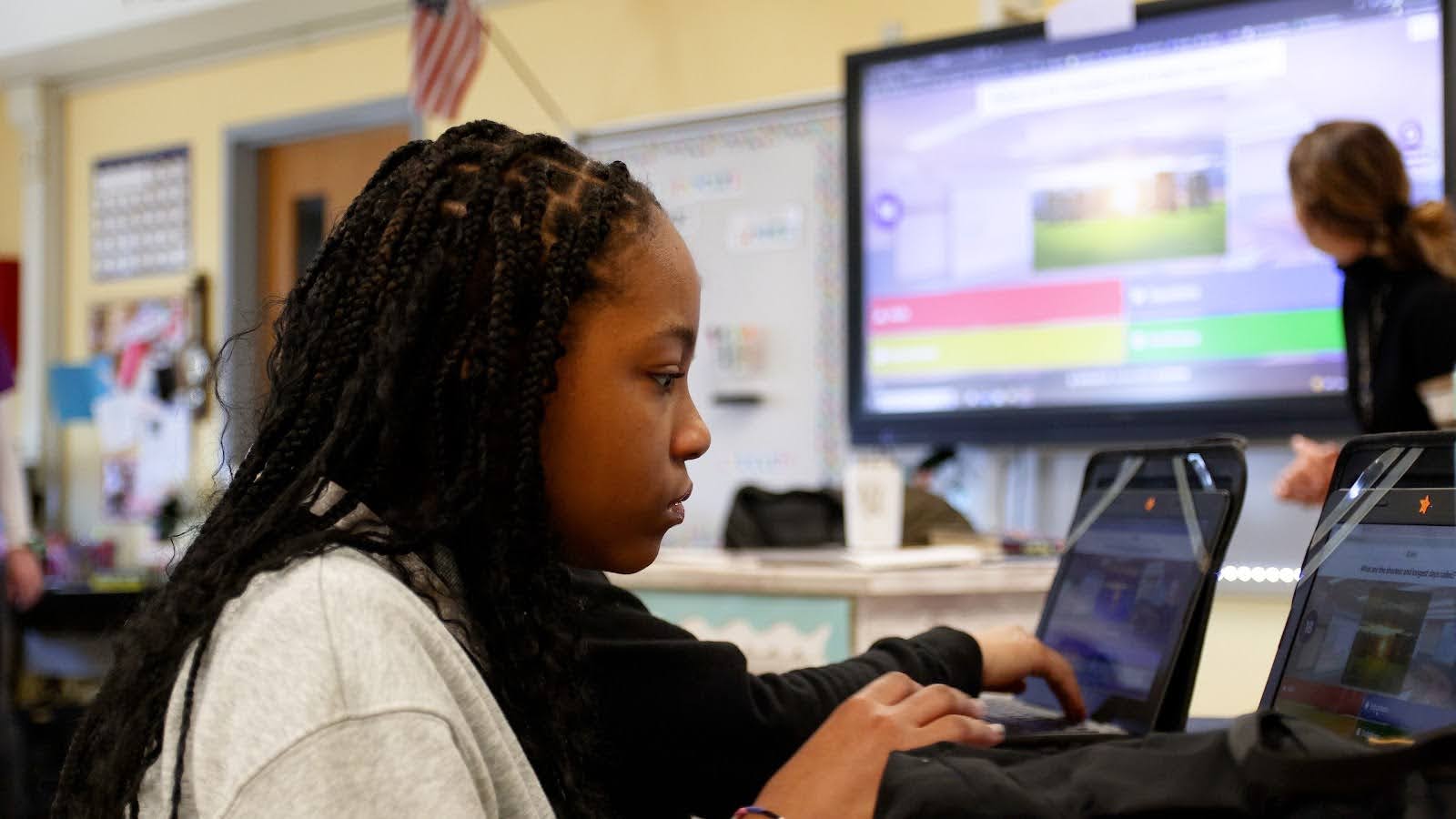 A student plays a kahoot in a classroom in front of a projector displaying Kahoot!