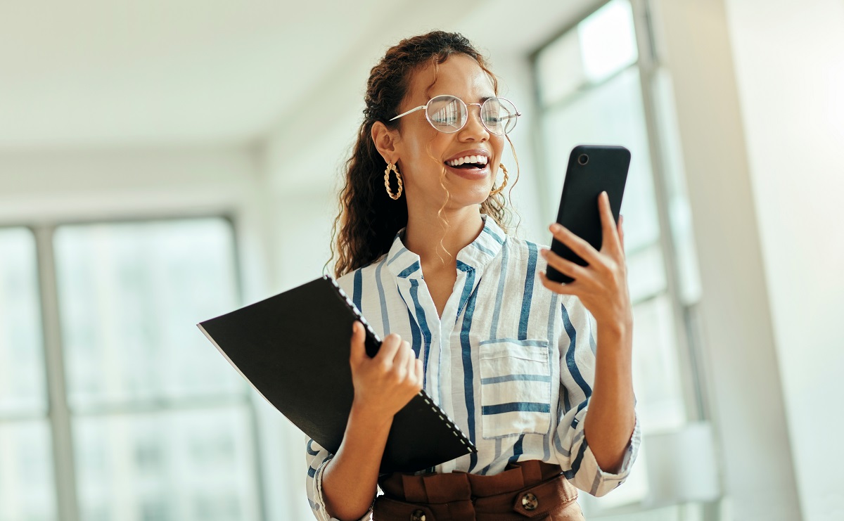 A female professional looking at a smartphone in an office