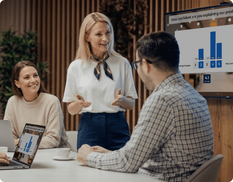 Presenter discussing Kahoot poll results with two colleagues in a meeting room