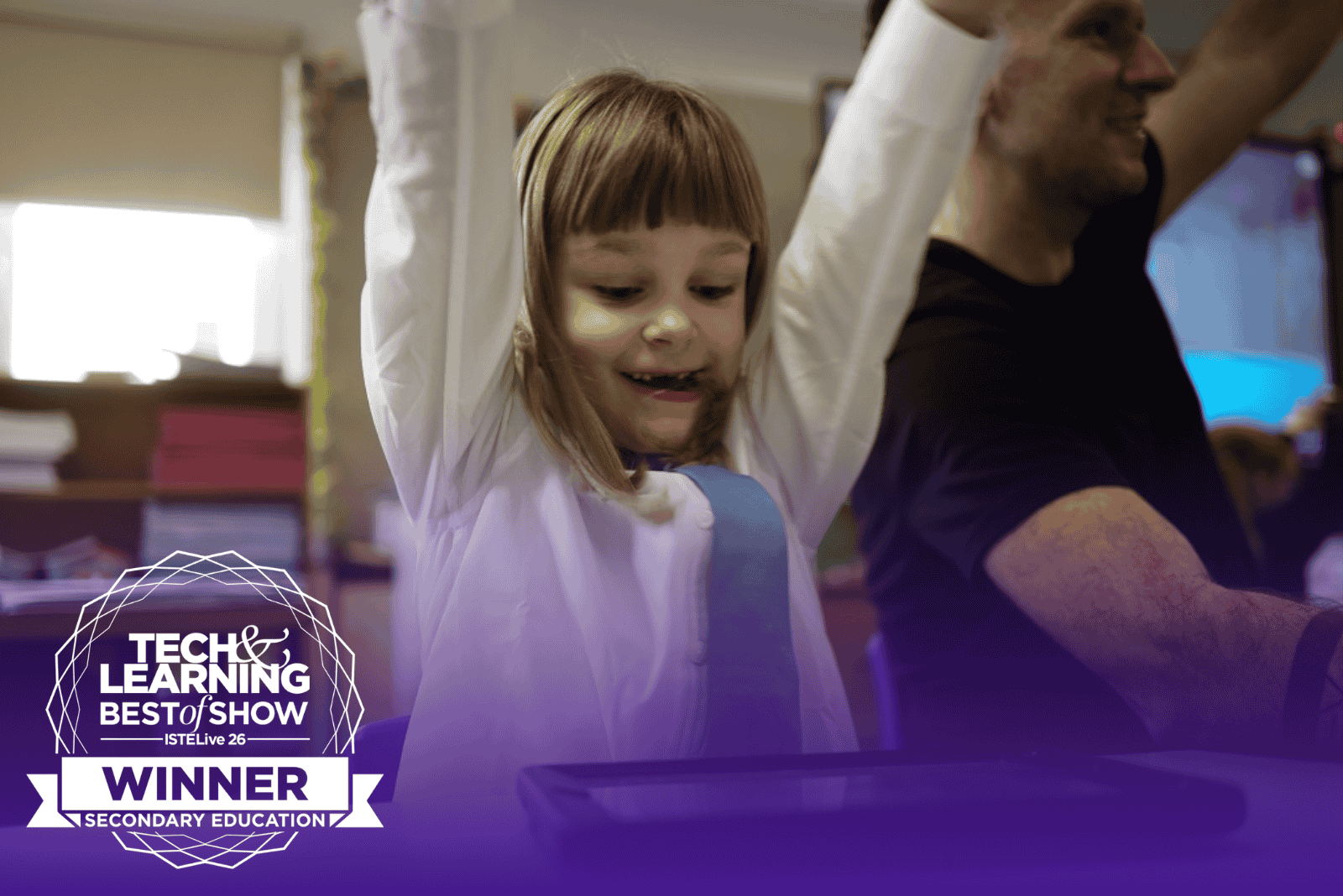 A young child with arms raised in celebration while playing Kahoot!