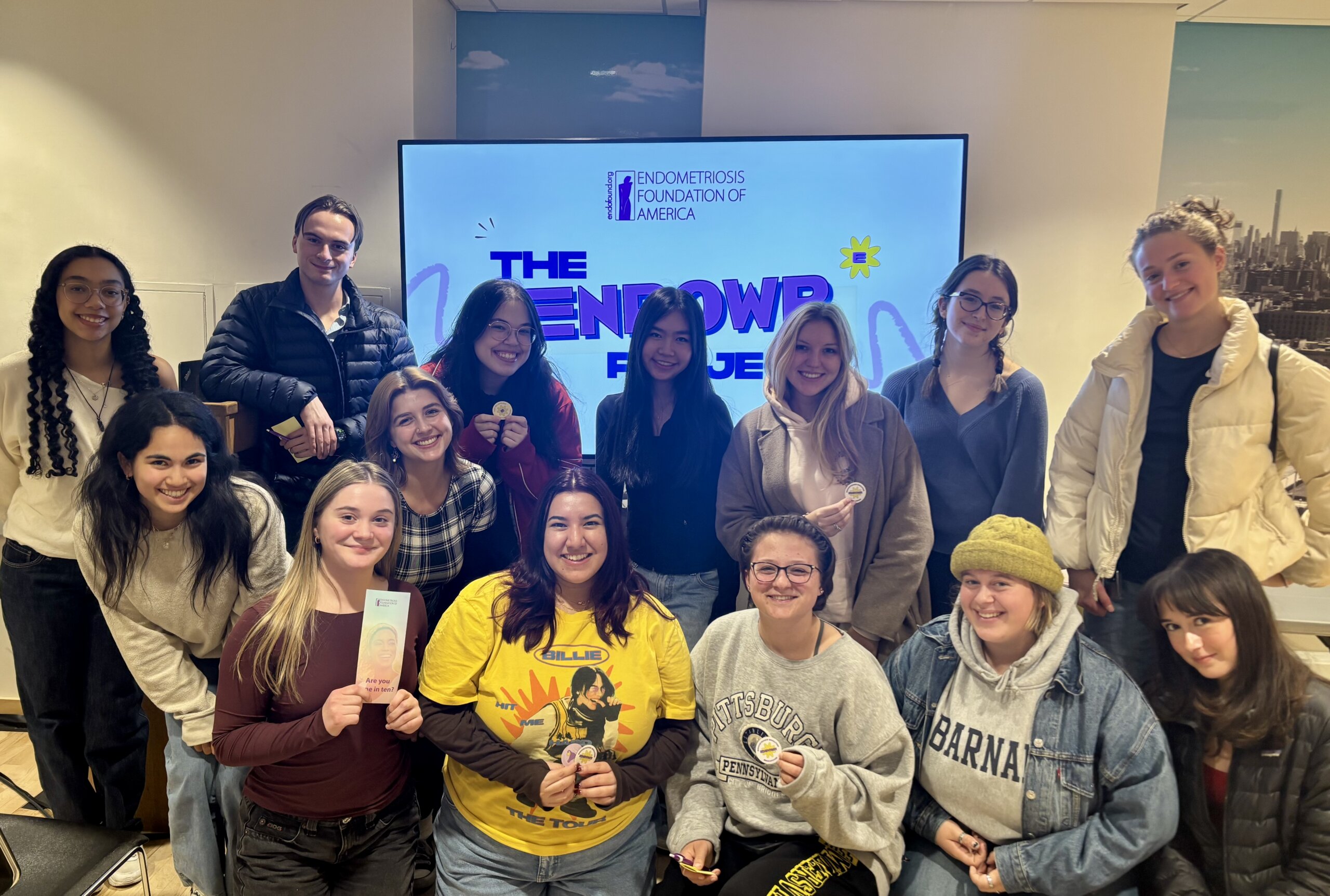 A group of Endometriosis Foundation team members in front of a screen displaying the ENPOWR Project logo